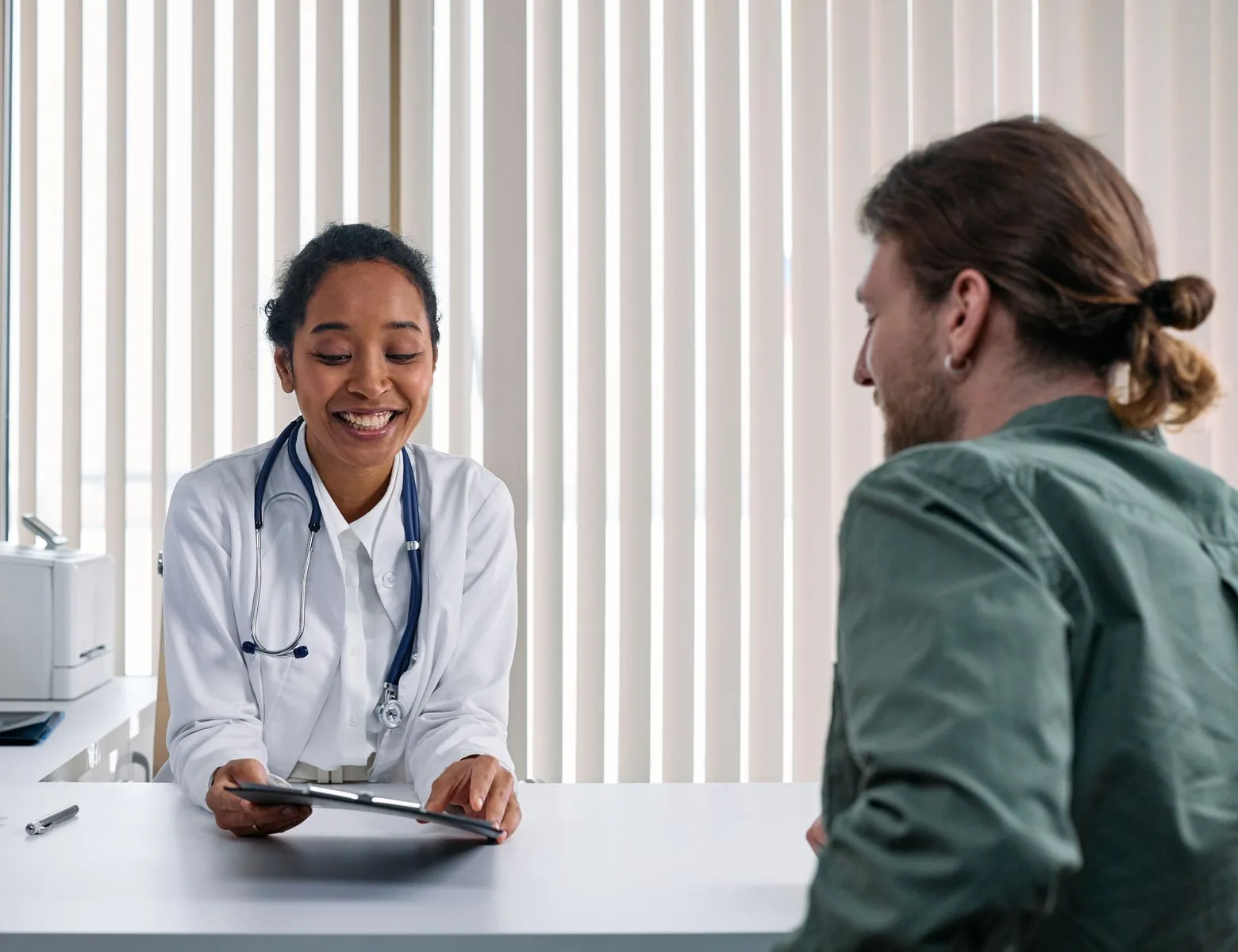 Smiling doctor consulting with a patient in a bright clinic