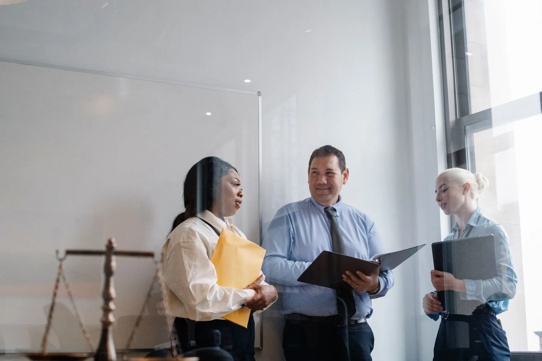 Legal professionals sharing a positive case discussion in a modern office